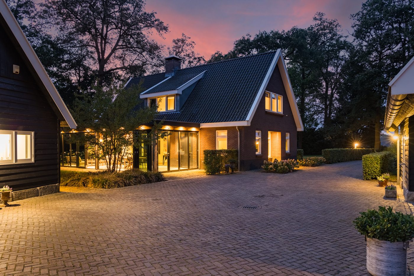 Het landhuis bij schemering, gezien vanaf de verlichte oprit