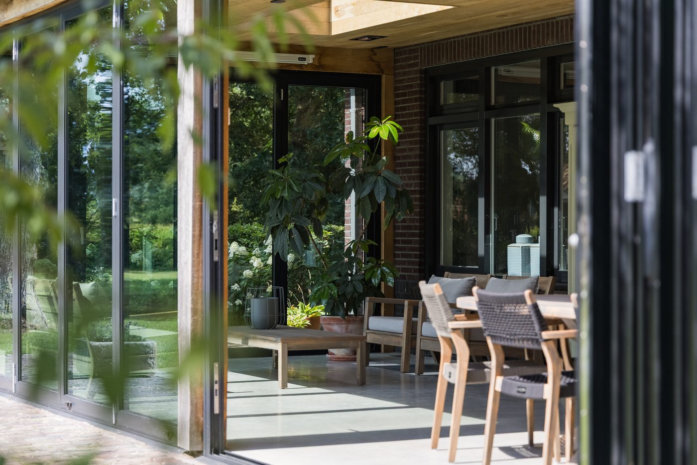 De serre met geopende harmonicadeuren naar het terras