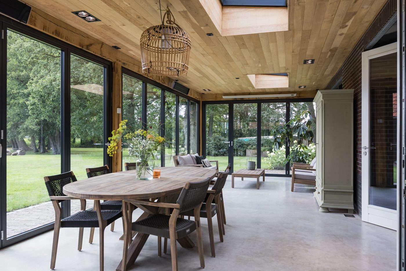 De eettafel in de serre met zicht op de tuin
