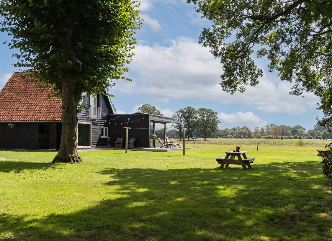 Het gazon met picknicktafel en vrij uitzicht over het weiland